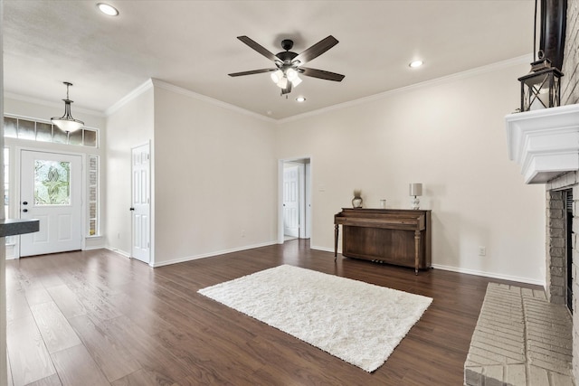 living area featuring baseboards, a brick fireplace, ceiling fan, and dark wood finished floors