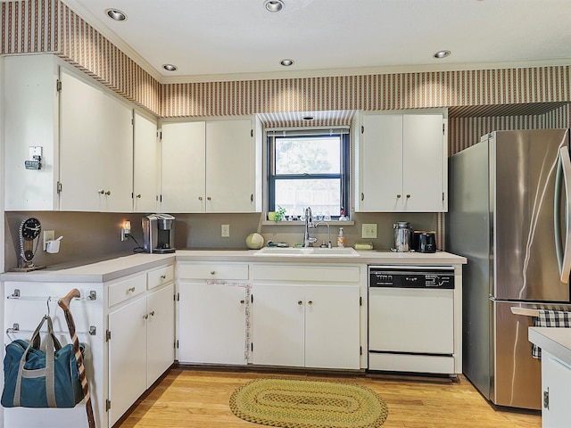 823 Cliffdale Ave, Dallas, TX 75211 - kitchen featuring a sink, dishwasher, light wood finished floors, light countertops, and freestanding refrigerator