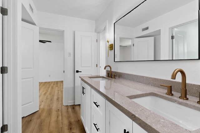7116 Town Bluff Dr, Dallas, TX 75248 - bathroom with double vanity, wood finished floors, and baseboards
