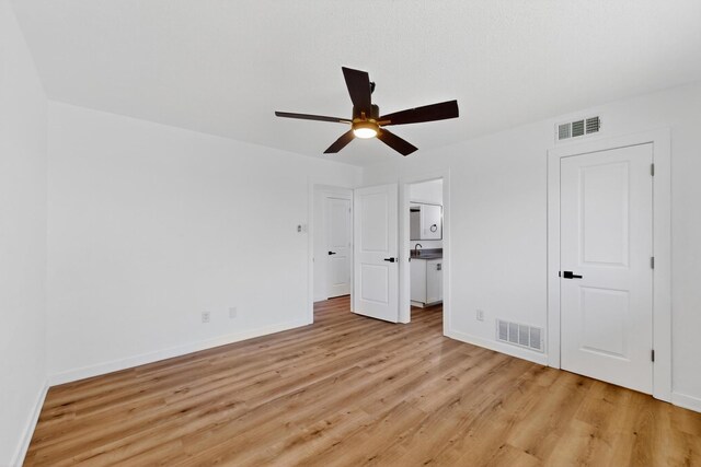 7116 Town Bluff Dr, Dallas, TX 75248 - unfurnished bedroom with light wood-style floors, baseboards, a ceiling fan, and connected bathroom