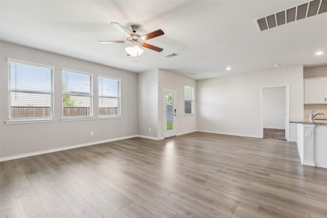unfurnished living room with visible vents, light wood finished floors, and ceiling fan