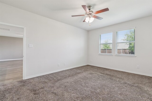 spare room with carpet floors, baseboards, and ceiling fan