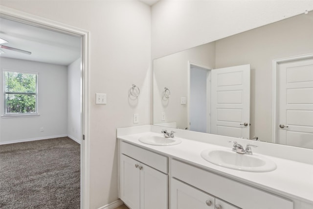 bathroom featuring double vanity, baseboards, and a sink