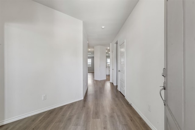 hall featuring wood finished floors and baseboards