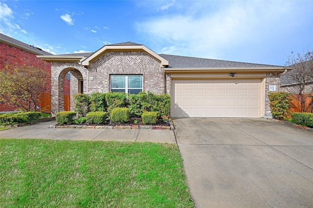 ranch-style house featuring concrete driveway, brick siding, a garage, a shingled roof, and a front yard