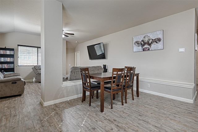 dining room with ceiling fan, lofted ceiling, wood finished floors, and baseboards