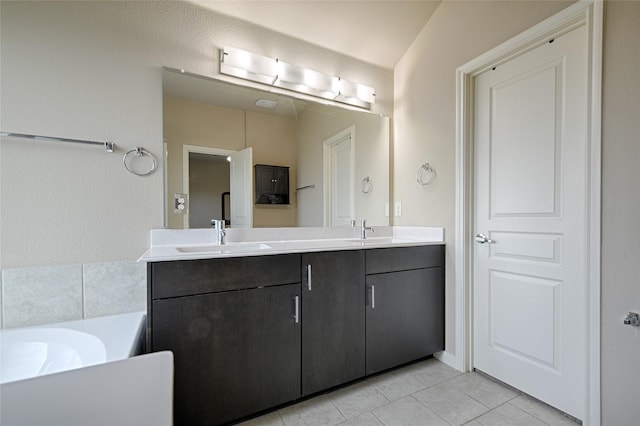 full bath featuring tile patterned floors, a sink, double vanity, and a bathing tub