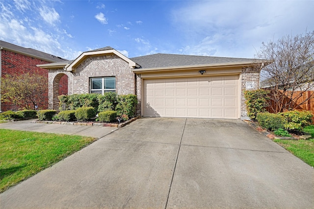 ranch-style home featuring a garage, driveway, brick siding, and fence