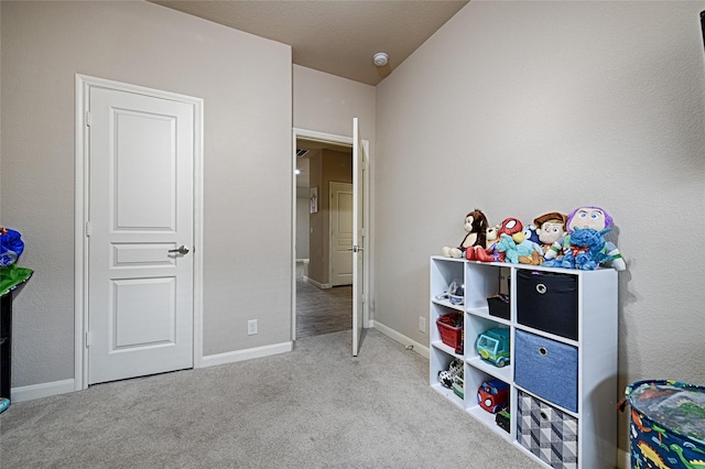 recreation room with baseboards and carpet
