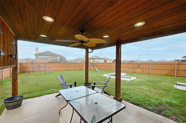 view of patio / terrace featuring a fenced backyard, a mountain view, outdoor dining space, and a playground