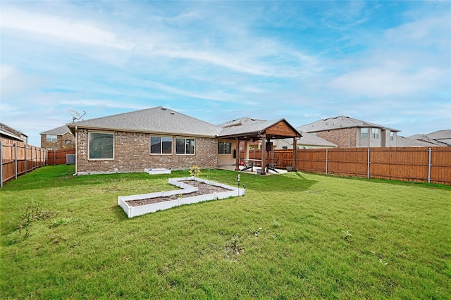 back of property featuring a fenced backyard, brick siding, a yard, and a patio
