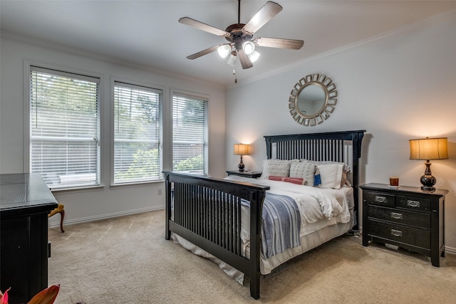 carpeted bedroom featuring a ceiling fan, baseboards, and ornamental molding