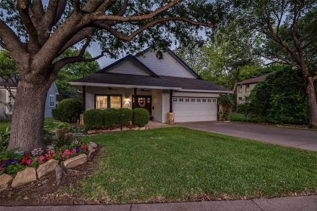 view of front facade with a front lawn, covered porch, concrete driveway, a garage, and ceiling fan