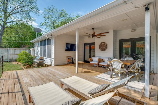 wooden deck with french doors, a grill, fence, a ceiling fan, and outdoor dining area