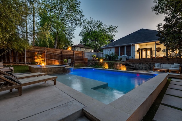 pool at dusk with a fire pit, a fenced backyard, a fenced in pool, an in ground hot tub, and stairs
