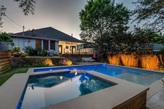 view of swimming pool with a fenced backyard, a fenced in pool, and an in ground hot tub