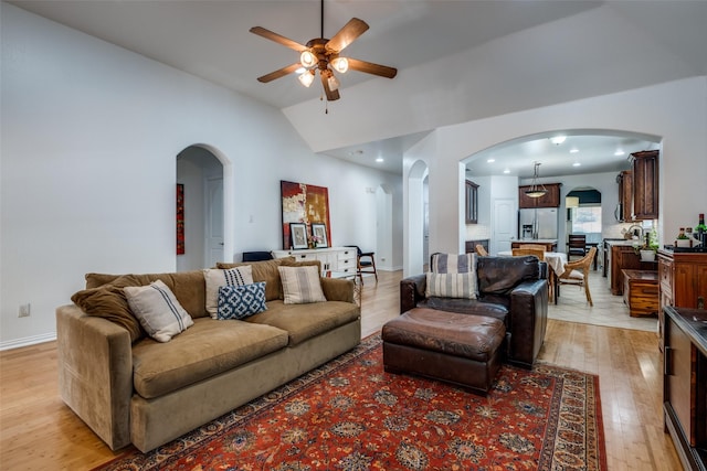 living area featuring light wood-style flooring, arched walkways, vaulted ceiling, recessed lighting, and ceiling fan