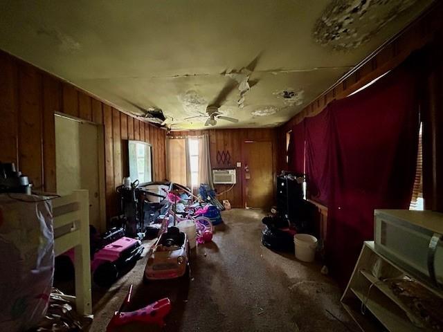 miscellaneous room with wood walls, carpet flooring, and a wall mounted AC