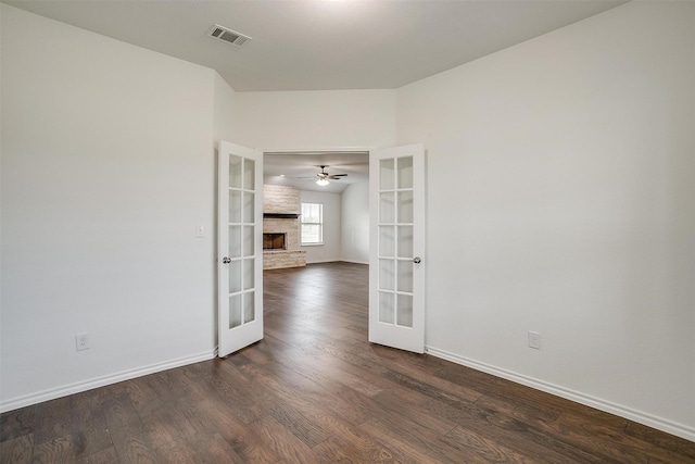 spare room with visible vents, a ceiling fan, french doors, dark wood-type flooring, and baseboards