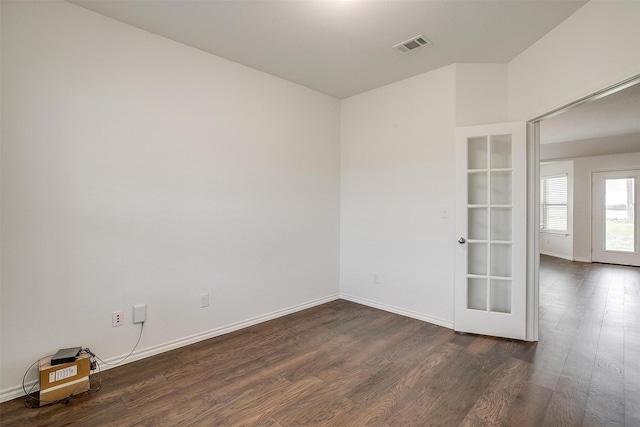 empty room featuring dark wood finished floors, baseboards, and visible vents