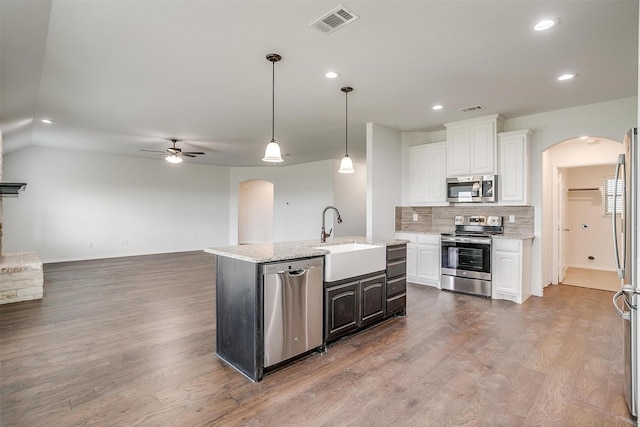 kitchen featuring stainless steel appliances, visible vents, a sink, arched walkways, and ceiling fan