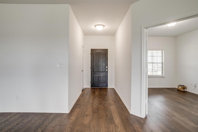 hall featuring baseboards and dark wood finished floors