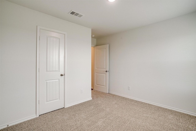unfurnished bedroom featuring visible vents, baseboards, and light carpet