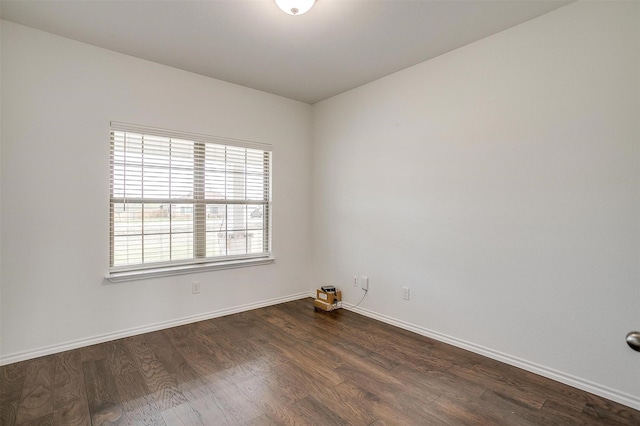 unfurnished room with dark wood-type flooring and baseboards