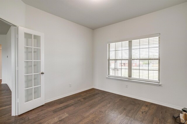 empty room featuring baseboards and dark wood-style floors