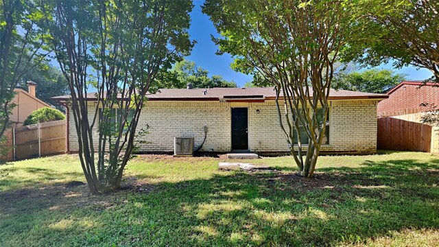 1814 Novel Dr, Garland, TX 75040 - back of house with brick siding, central AC unit, fence, and a lawn