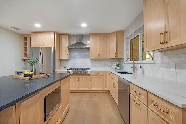 9603 Greensprint Dr, Dallas, TX 75238 - kitchen featuring light brown cabinets, stainless steel appliances, wall chimney range hood, light wood-type flooring, and decorative backsplash