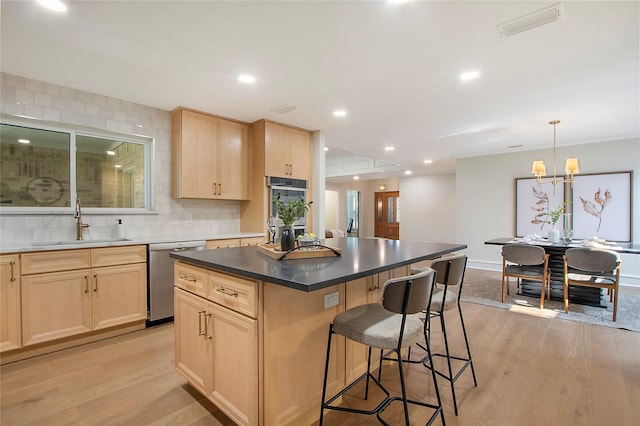 9603 Greensprint Dr, Dallas, TX 75238 - kitchen featuring appliances with stainless steel finishes, light brown cabinets, light wood-style floors, a breakfast bar, and recessed lighting