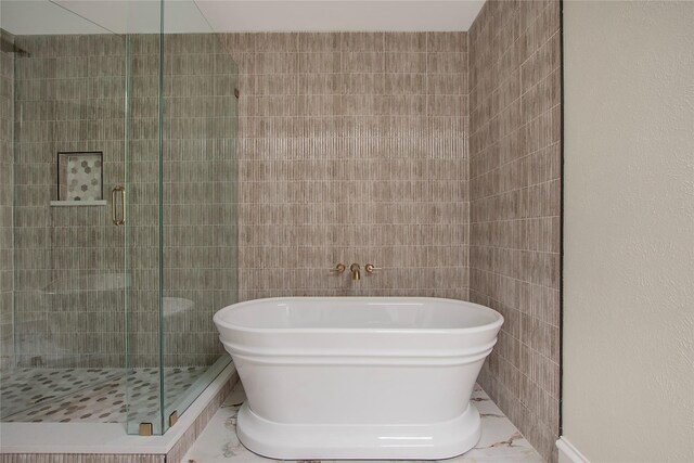 9603 Greensprint Dr, Dallas, TX 75238 - bathroom featuring marble look tile flooring, a soaking tub, and a shower stall