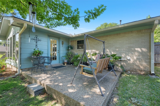 rear view of house featuring brick siding and a patio