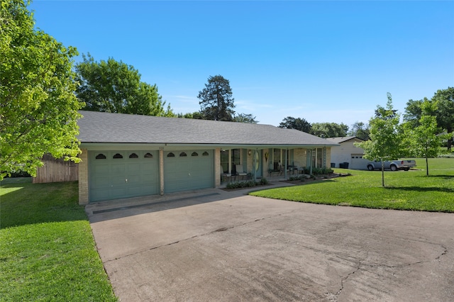 ranch-style home with a front lawn, concrete driveway, covered porch, brick siding, and a garage