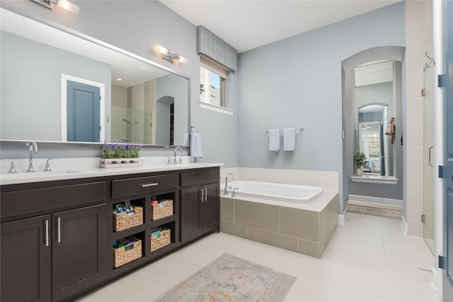 full bathroom with tile patterned flooring, a garden tub, a sink, and a stall shower