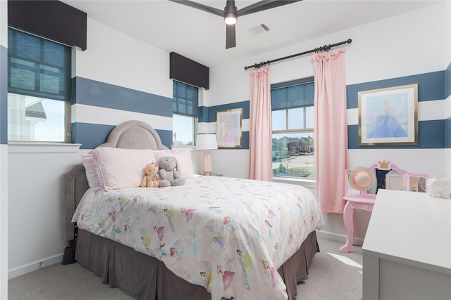 carpeted bedroom with visible vents, a ceiling fan, and baseboards