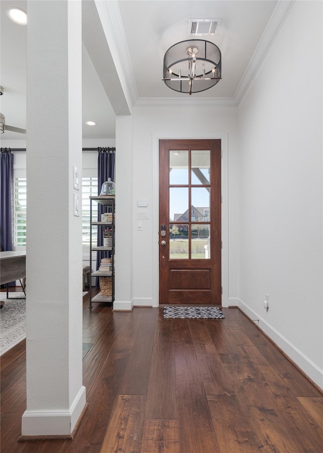 foyer entrance with visible vents, crown molding, dark wood-style floors, and a wealth of natural light