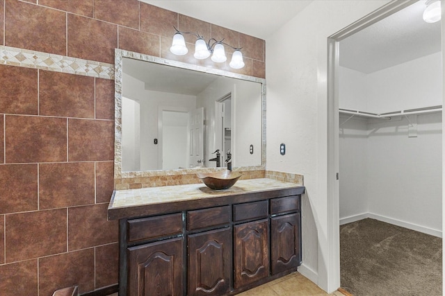 full bathroom with vanity and a walk in closet