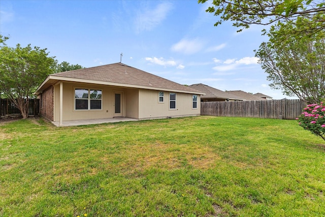 back of property featuring a fenced backyard, a yard, and a patio area