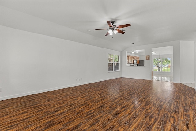 unfurnished living room featuring ceiling fan, baseboards, a healthy amount of sunlight, and dark wood-style floors