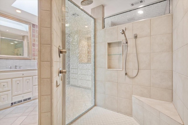 bathroom featuring vanity, walk in shower, tile patterned flooring, and visible vents