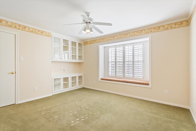 carpeted empty room with baseboards and ceiling fan