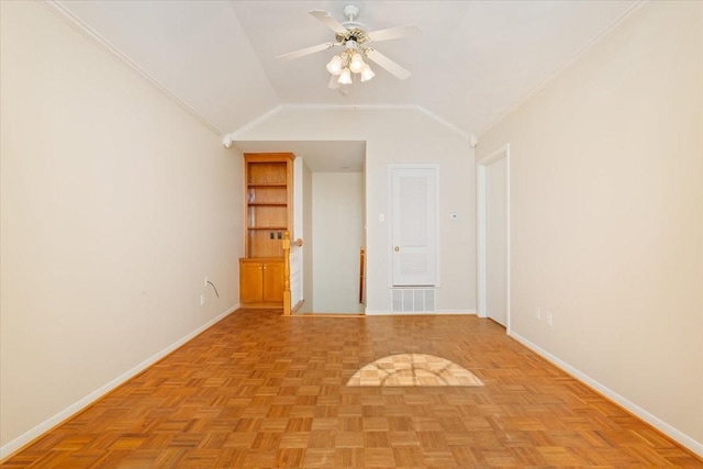 spare room featuring lofted ceiling, visible vents, a ceiling fan, ornamental molding, and baseboards
