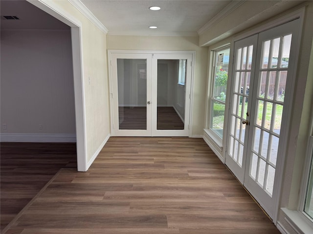 interior space with visible vents, french doors, baseboards, and crown molding
