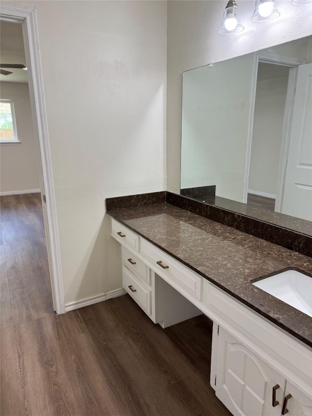 bathroom featuring baseboards, vanity, and wood finished floors