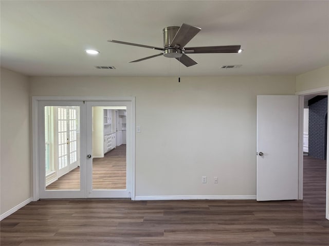 empty room with wood finished floors, visible vents, baseboards, and ceiling fan