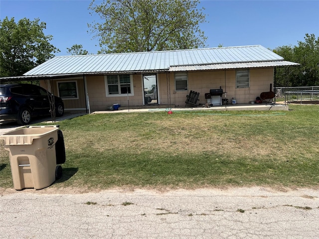 view of front facade with a front lawn, metal roof, and fence