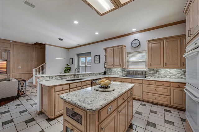 4524 Tuscany Dr, Plano, TX 75093 - kitchen featuring a sink, a peninsula, tasteful backsplash, ornamental molding, and open floor plan