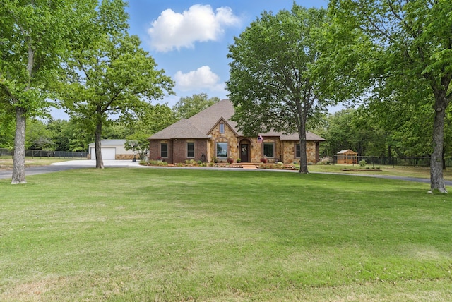 view of front of house with fence, driveway, a front lawn, and a garage